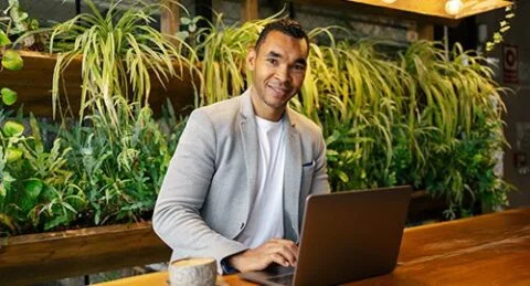 Smiling small business owner working on laptop